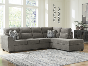 Experience ultimate comfort with the Olten 2-Piece Sectional. Featuring soft mocha upholstery, geometric pillows, and a sag-resistant platform foundation. Shop SKU 3130.